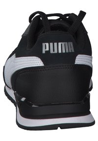 Baskets noir et blanc avec une tige en cuir texturé, une semelle en caoutchouc et un logo "PUMA" bien visible sur le talon. Comprend des lacets noirs.