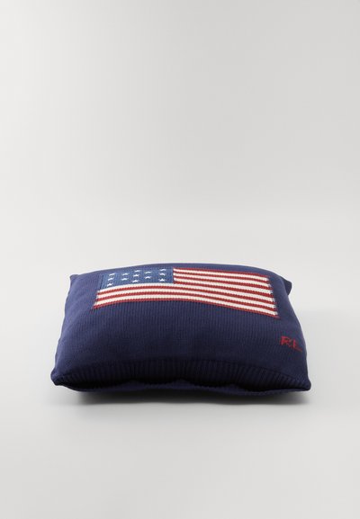 Marinepude med en broderet amerikansk flag i rød, hvid og blå. Bemærk den tykke strikkede tekstur og den røde skrift på siden.