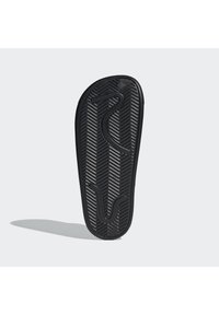 Soletta per scarpe in gomma nera con superficie testurizzata che presenta schemi a zigzag e curve per una presa e supporto ottimali. Progettata per comfort e durata.