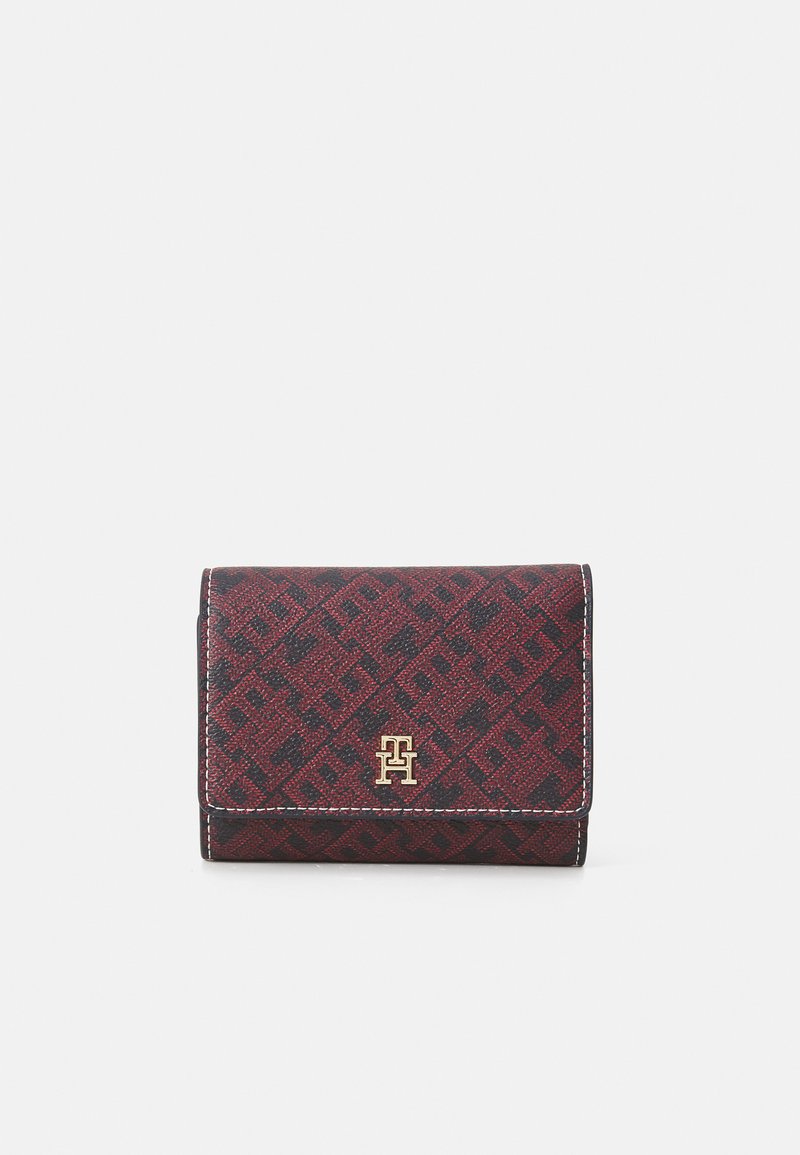 Folded wallet in dark red and black patterned fabric. Features a gold logo and white stitching. Compact rectangular shape. Textured surface.