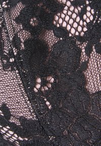 Tecido de renda floral preto com uma camada de malha por baixo, apresentando padrões de flores intrincados e uma textura delicada.