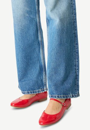 Rode patenten lederen balletschoenen met een ronde neus en een decoratieve enkelband, gecombineerd met lichtblauwe wijde denim jeans.