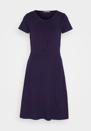 Dark purple short-sleeve dress with a round neckline, subtle pleats at the bust and waist, and a flared A-line skirt. Soft fabric texture.