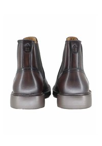 Stivaletti alla caviglia in pelle marrone con pannelli elastici laterali, punte arrotondate e una texture liscia. Presentano una suola in gomma grigia a contrasto.