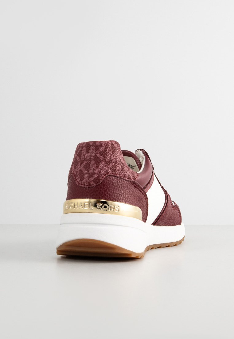 Zapatilla de cuero roja con detalles en blanco, branding dorado en el talón, panel trasero texturizado y suela de goma con un diseño estampado.