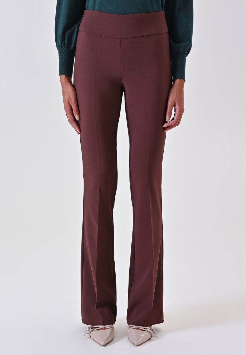 Pantaloni svasati bordeaux realizzati in un tessuto liscio e texturizzato con una vita alta, caratterizzati da cuciture frontali per un fit su misura.