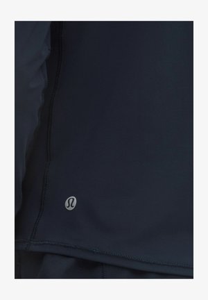 Marineblaues Sportoberteil aus elastischem Stoff mit glatter Textur, genähten Nähten und einem kleinen Logotag nahe dem Saum.