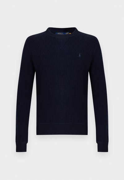 Μπλε πουλόβερ πλεκτό σε ναυτικό μπλε χρώμα με V-λαιμόκοψη, ριμπ υφή και μακριά μανίκια. Διαθέτει μικρό κεντημένο λογότυπο στο αρ ιστερό στήθος.