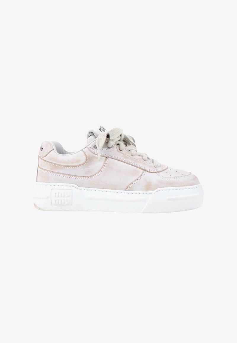 Baskets basses en daim beige avec semelle blanche épaisse, fermeture à lacets à l’avant, et logo discret sur le talon et la semelle, vues de profil.