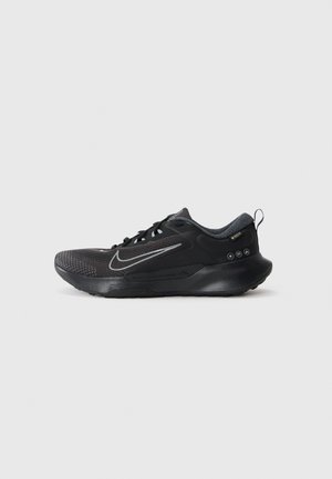 Schwarze Nike-Sneaker mit einem atmungsaktiven Mesh-Obermaterial, glatten synthetischen Akzenten, reflektierendem Logo und strukturiertem Sohlenprofil für besseren Grip.