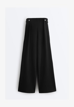 Musta, korkeavyötäröinen, leveälahkeinen housut, joissa on napilliset vyötärönauhakiinnikkeet ja sileä etupuoli, valkoisella taustalla esitetty.