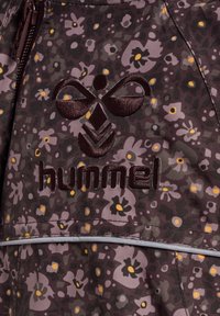 Mørk lilla blomstermønstrede stof har et hævet logo "hummel" og dekorative accenter i kontrastfarver med en lynlås lukning.