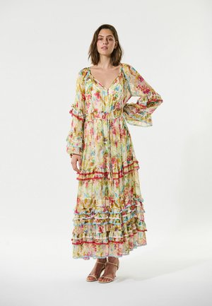 Florale maxi-jurk in doorschijnende stof, met levendige kleuren, geplooide lagen, een strakke taille en lange mouwen met rimpelige manchetten.