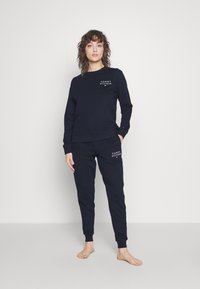 Completo felpa e pantaloni jogger blu navy in cotone, con stampa del logo sul davanti e polsini a coste su entrambi i pezzi.