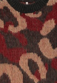 Maglione lavorato a maglia con un colletto a coste di colore nero, caratterizzato da un motivo testurizzato in rosso, beige e tonalità scure, creando un design a contrasto.