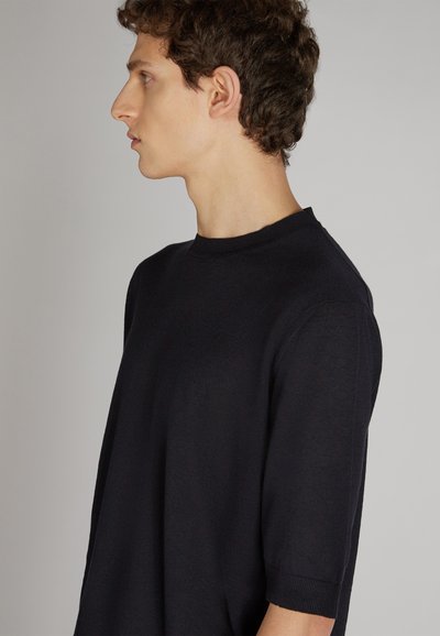 Schwarzer Kurzarmpullover mit Rundhalsausschnitt, ausgestattet mit einem strukturierten Strickmuster und einem lässigen Schnitt. Sichtbarer Rippenbesatz am Saum und an den Ärmelbündchen.