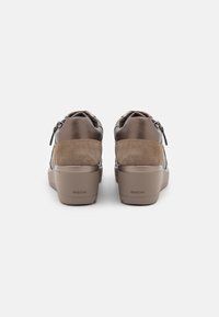 Zapatillas de cuero marrón con acentos de ante, un cuello acolchado y diseño de puntera redonda. Presenta un tirador trasero y un tacón en cuña.