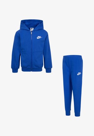 Modra kapuca s puloverjem in usklajenimi trenirkami iz mehkega blaga. Vključuje sprednji zadrgo in bel Nike logotip na obeh kosih.