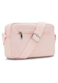 Różowa materiałowa torba na ramię z kieszenią na zamek, w kształcie prostokąta, o miękkiej fakturze oraz regulowanym paskiem z metalowymi dodatkami.