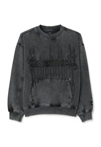 Sudadera gris con cuello redondo, que presenta un bolsillo frontal y un detalle gráfico texturizado en negro en el centro. Tejido suave, ajuste relajado.