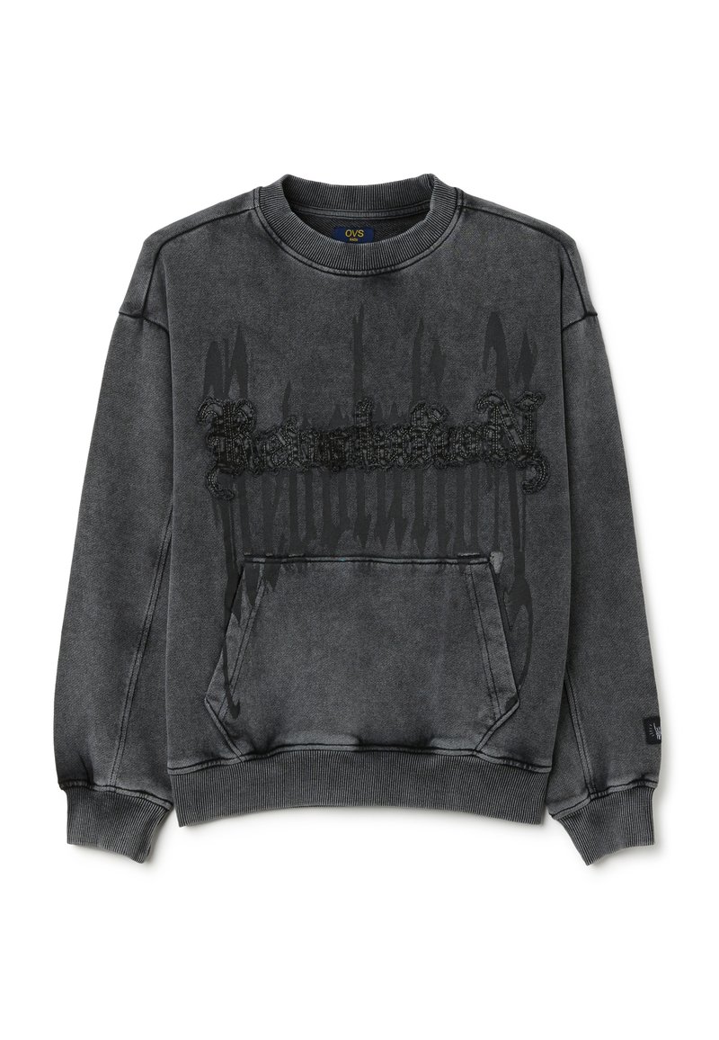 Sudadera gris con cuello redondo, que presenta un bolsillo frontal y un detalle gráfico texturizado en negro en el centro. Tejido suave, ajuste relajado.