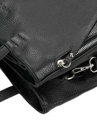 Borsa a mano in pelle nera con superficie testurizzata, zip e dettagli hardware in argento. Progettata con doppi manici e un ampio interno.