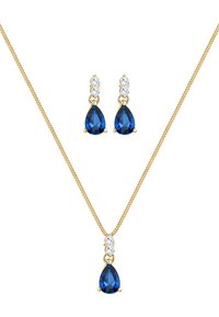 Gouden sieraden set met een druppelvormige blauwe edelsteen hanger en bijpassende oorbellen met heldere steenkralen. Het kettingontwerp is delicaat.