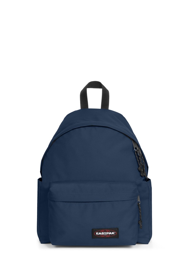 Sac à dos en nylon bleu marine avec un compartiment principal, une poche zippée à l'avant et une poignée sur le dessus. Il présente un patch logo et des bretelles ajustables.