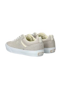 Beige suède lage sneakers met witte rubberen zolen en veters, met een subtiel logo en lichtgekleurde accenten op de zijpanelen.