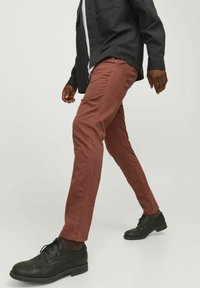 Rosa chinos i bomull, slim fit, med en mjuk struktur. Bärs med svarta snörskor och bruna strumpor.