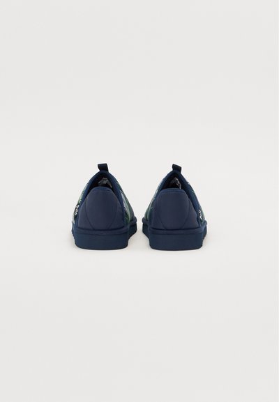 Marinefargede slip-on sko med teksturert finish, rund tå og en pull-tab på hælen. Grønt blomstermønster på sidene. Myk gummisåle.