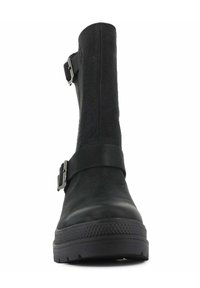 Botín negro con acabado de cuero texturizado, que cuenta con dos hebillas metálicas ajustables y una suela de goma resistente para mayor tracción.