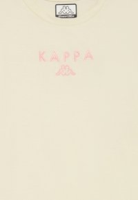 Grietai spalvos marškinėliai pagaminti iš minkštos medvilnės, su rožiniu siuvinėjimu "KAPPA" ir logo, esančiu marškinėlių centre. Apvali iškirptė.
