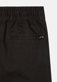 Zwarte shorts met elastische tailleband, gemaakt van duurzaam materiaal, met een achterzak en een klein merklabel aan de achterkant.