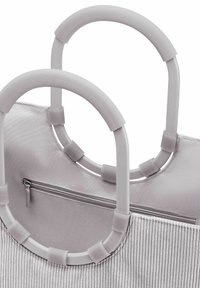 Borsa tote in tessuto grigio con due manici circolari. Il corpo testurizzato presenta righe verticali, una tasca interna con zip e accenti con manici imbottiti.