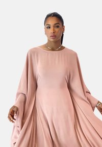 Flowing pink dress with wide sleeves, made from soft fabric. Features a rounded neckline and draped design, creating an elegant silhouette.