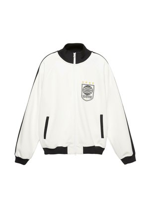 Biała kurtka na zamek z czarnym kołnierzem, mankietami i wykończeniem kieszeni; czarne paski na rękawach; naszywka z globusem i gwiazdami na piersi.