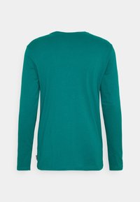 Teal long-sleeve t-shirt with a crew neckline, made of soft fabric. Features a smooth texture and a plain design, no visible graphics or patterns.