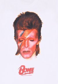 Camiseta blanca de algodón con un gran gráfico colorido de una cara con un diseño de rayo, acompañado del nombre "BOWIE" en texto rojo debajo.