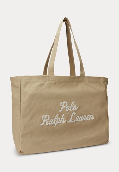 Μπεζ τσάντα χειρός από καμβά με διπλές λαβές και κεντημένο το λογότυπο "Polo Ralph Lauren" με λευκά γράμματα στην μπροστινή πλευρά.