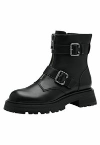 Bottines noires en cuir avec une semelle épaisse, fermeture éclair sur le côté et sangles réglables avec des boucles en métal pour un détail supplémentaire.
