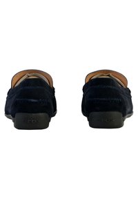 Mocassini in suede blu navy con suola piatta in gomma nera, caratterizzati da cuciture decorative e un interno in pelle liscia. Logo Geox sulla suola.