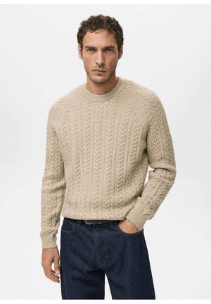 Suéter beige de punto grueso con cuello redondo y dobladillo acanalado. Se lleva con jeans azul oscuro, con mangas largas y un patrón texturizado.