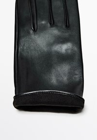 Zwarte leren handschoen met een gladde textuur, met een veilige pasvorm en een zachte fleece voering aan de manchette. Vijfvingerontwerp.