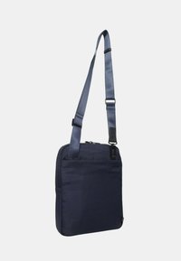 Borsa a tracolla blu navy in tessuto resistente, forma rettangolare con tracolla regolabile, tasca frontale con zip e design minimalista.