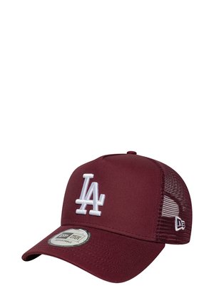 Gorra trucker color marrón con el logo "LA" bordado en blanco, parte trasera de malla y visera curva. Presenta un cierre ajustable a presión y un tejido texturizado.