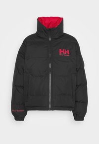Sort pufferjakke med rød indvendig beklædning, der har en frontlynlås, høj krave og Helly Hansen-logo i rødt på brystet og ærmet.