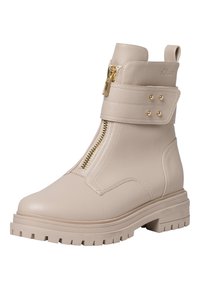 Bottines beiges en simili cuir, avec une fermeture éclair sur le côté, une sangle décorative à boucle, des accents dorés, et une semelle épaisse texturée.