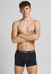 Schwarze Baumwoll-Boxershorts mit einem weißen "JACK & JONES"-Logo am Bund, mit einer engen Passform und glatter Textur.