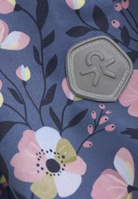 Tkanina kwiatowa z granatowym tłem i wielokolorowymi kwiatami w odcieniach różu, żółci i bieli, z szarym gumowym logo.